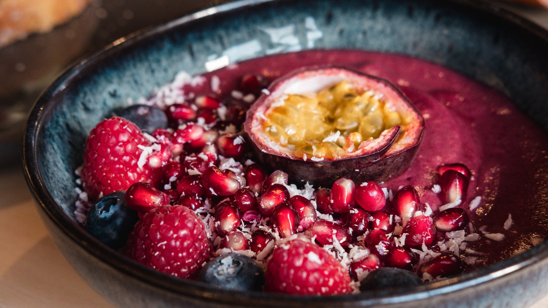 Brunch - das Langschläferfrühstück Schüssel mit Beeren, Granatapfelkernen und Passionsfrucht auf Smoothie