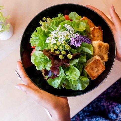 Kulinarik & Genuss in der Oberpfalz Frischer grüner Salat mit essbaren Blumen und gebratenem Halloumi in schwarzer Schale