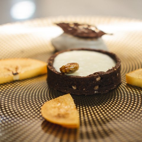 Restaurant in Parsberg: Gourmet genießen Schokoladentarte mit weißer Creme und karamellisierten Bananenscheiben auf Musterplatte