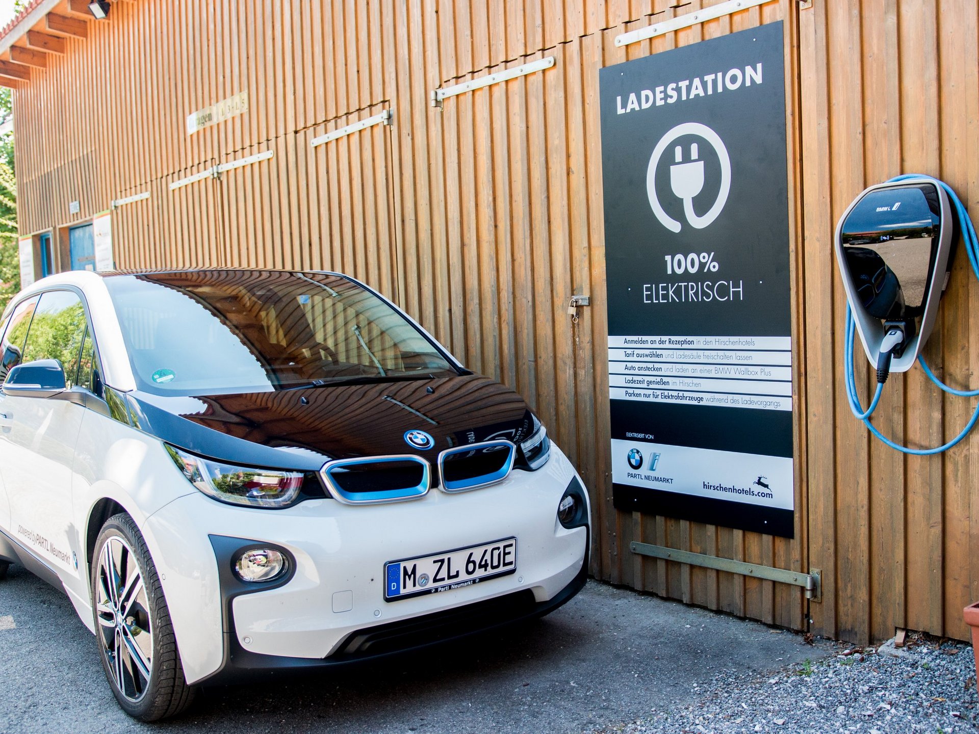 Everything you need for your stay. BMW i3 electric car at charging station with 100% electric sign