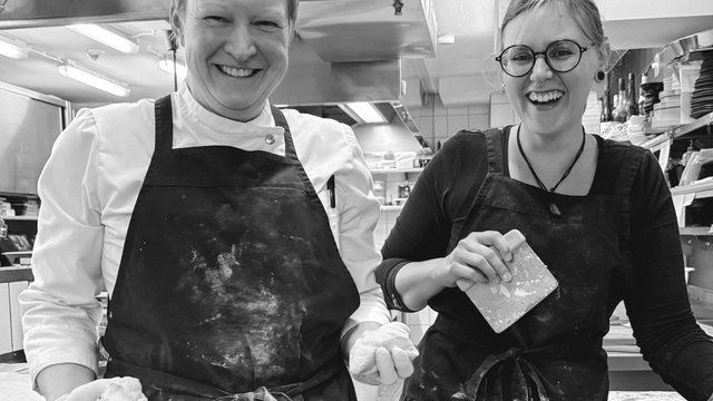 Nachhaltiges Hotel in Bayern mit Hirschenmanufaktur Zwei lachende Köchinnen mit schmutzbekleckerten Schürzen in einer Küche