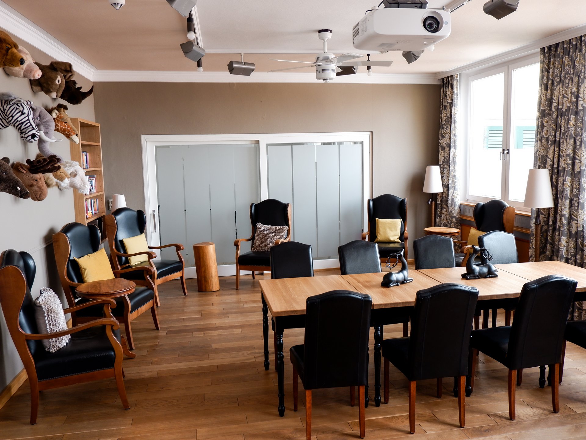 Tagungshotel Oberpfalz: Tagungsräume & Seminarräume im Romantik Hotel Hirschen Tagungsraum mit Holztisch, Ledersesseln und dekorativen Tierköpfen an der Wand