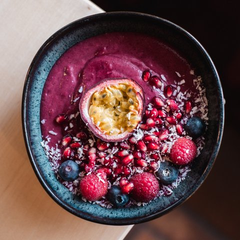 Brunch – breakfast for late risers Fruit smoothie bowl with passion fruit, raspberries, blueberries, and pomegranate seeds