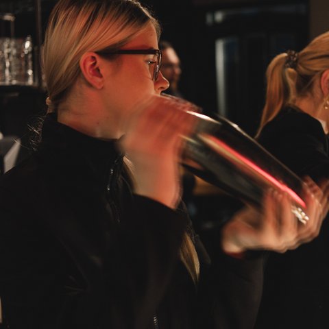 Hirschenblobb: Our bar Woman shaking a cocktail shaker in a bar