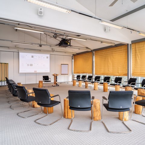 Looking for somewhere for conferences in Bavaria? Modern seminar room with chairs in a circle and wooden stools as tables
