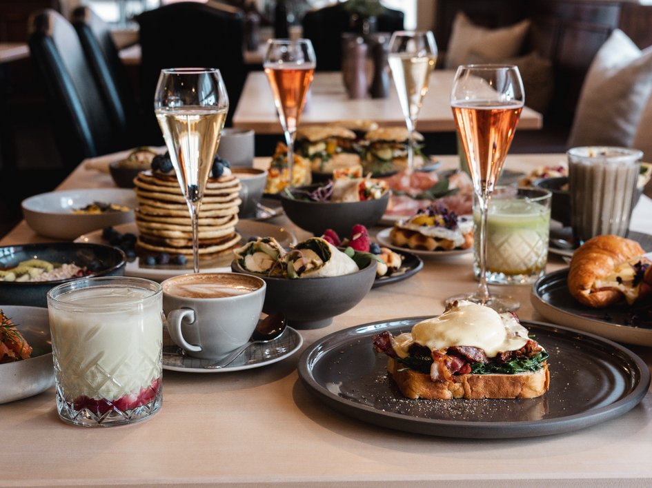 Brunch – breakfast for late risers Assorted breakfast dishes and drinks on a table in a café