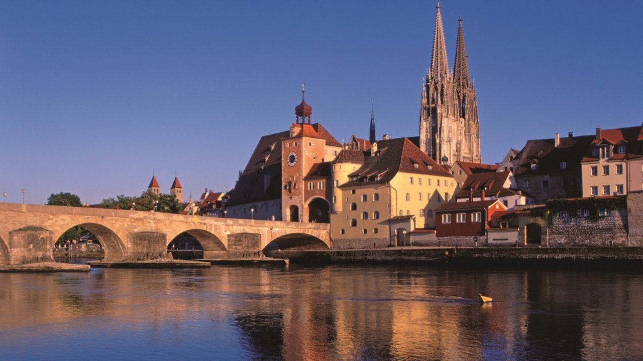 Nennenswertes Ausflugsziel Blick auf Regensburg mit Steinbrücke und Dom bei Sonnenuntergang