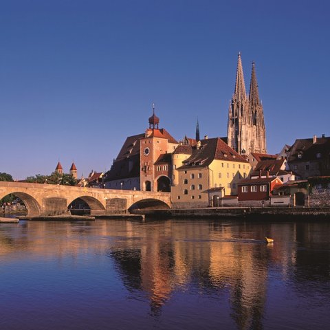 Hotels in Regensburg und Umgebung: kultur-trächtig! Blick auf Regensburg mit Steinbrücke und Dom bei Sonnenuntergang