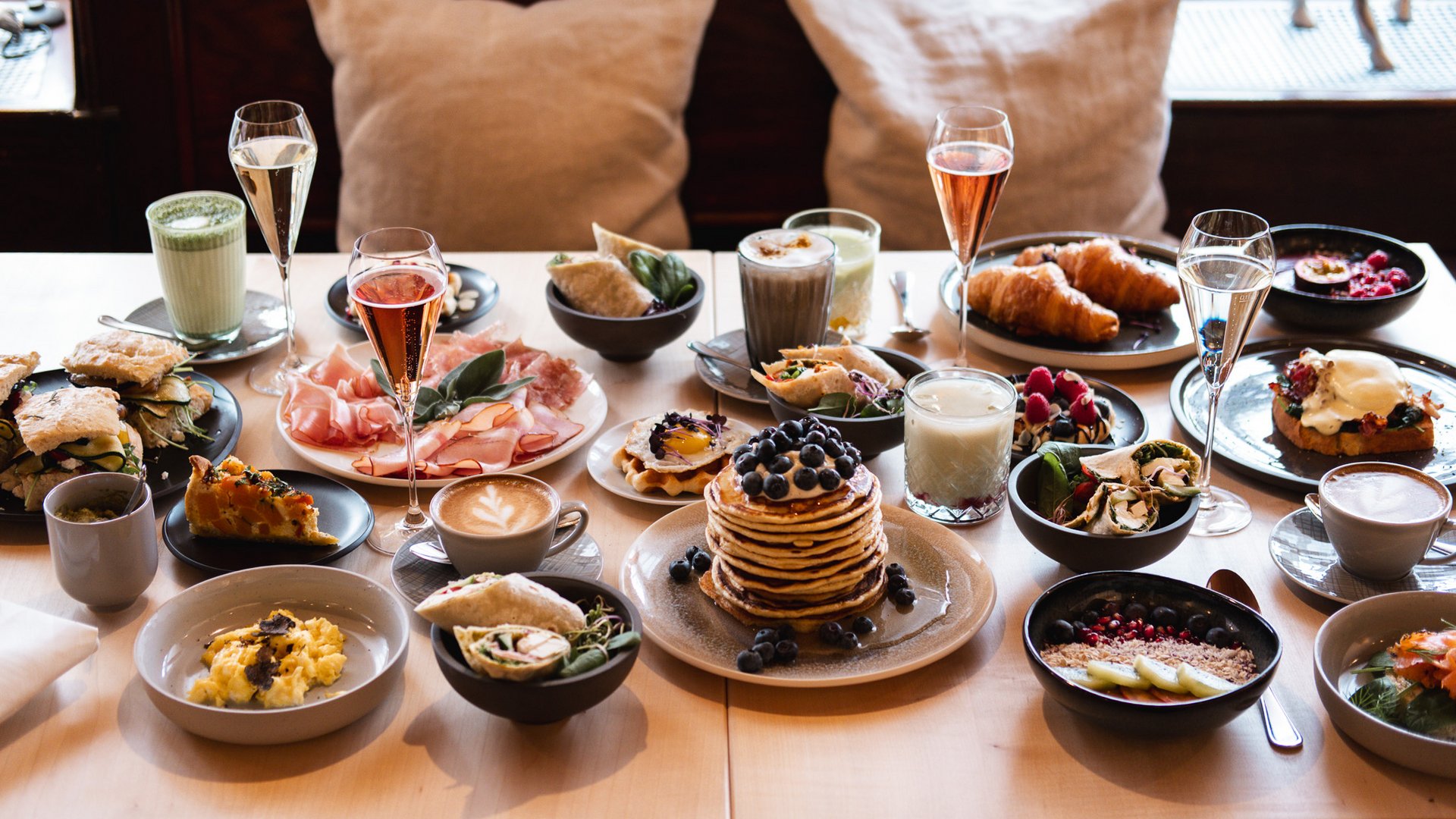 Brunch – breakfast for late risers Table with varied breakfast and drinks in a cozy setting