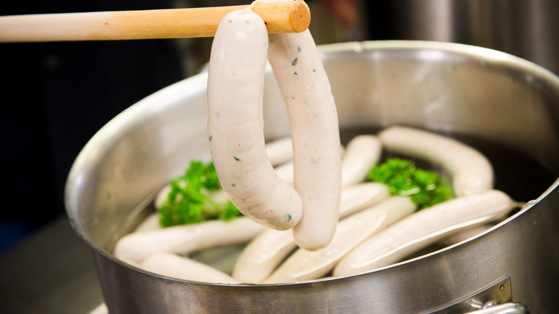 Services and rates for conferences and celebrations White sausages boiling in a large metal pot with parsley