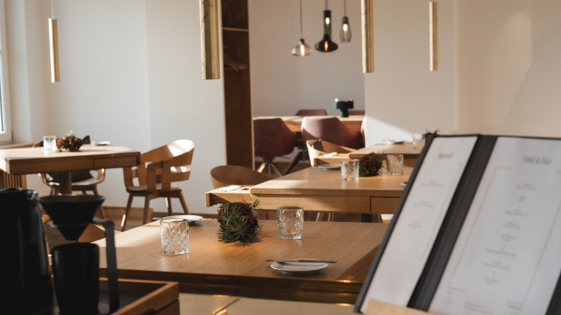 Event calendar 2026 Modern restaurant with wooden tables, glasses, and a menu on a stand