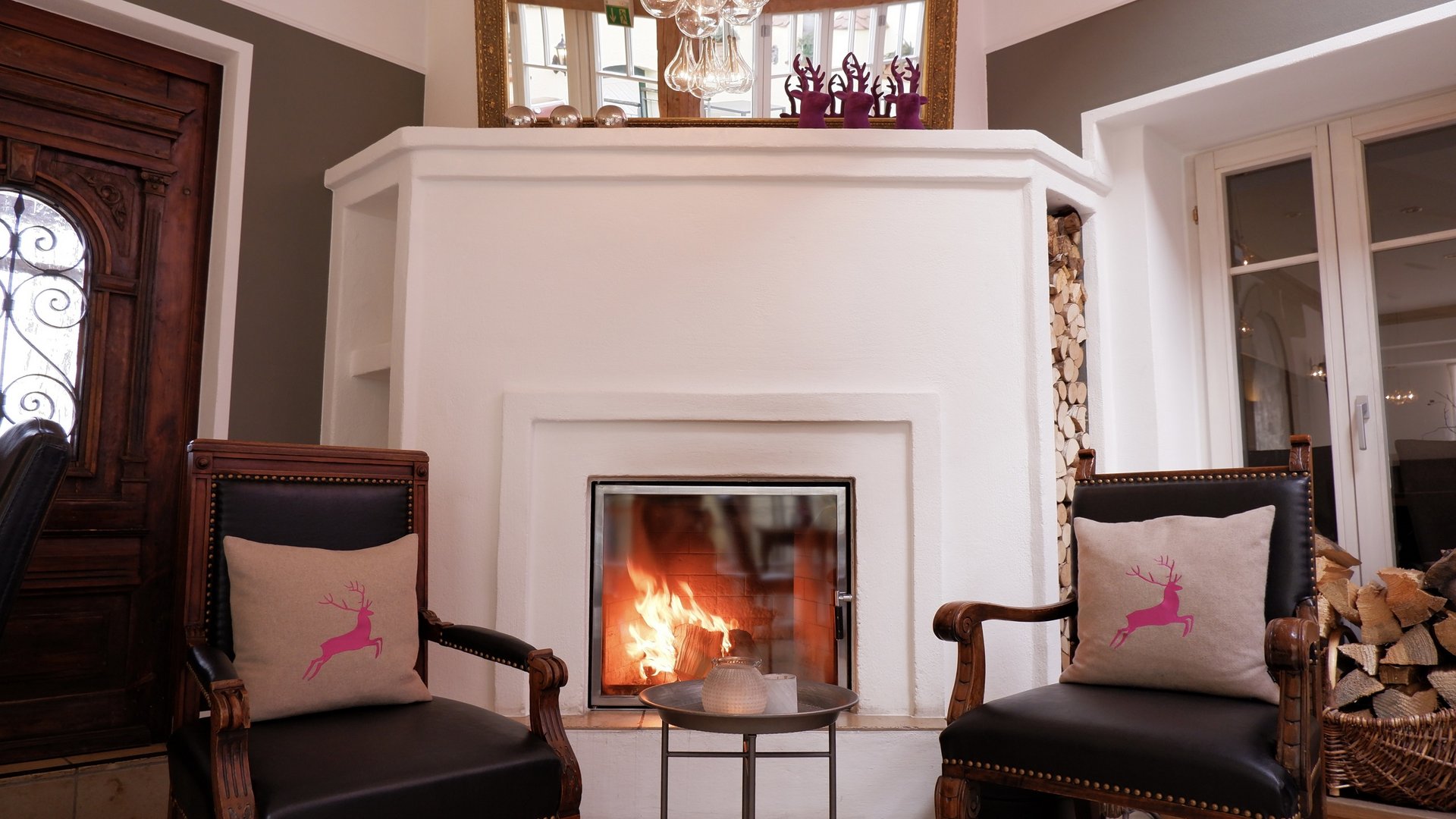 Romantik Hotel Hirschen: Blog Gemütliche Sitzecke mit Kamin, zwei Sesseln und Dekokissen mit Hirschmotiv
