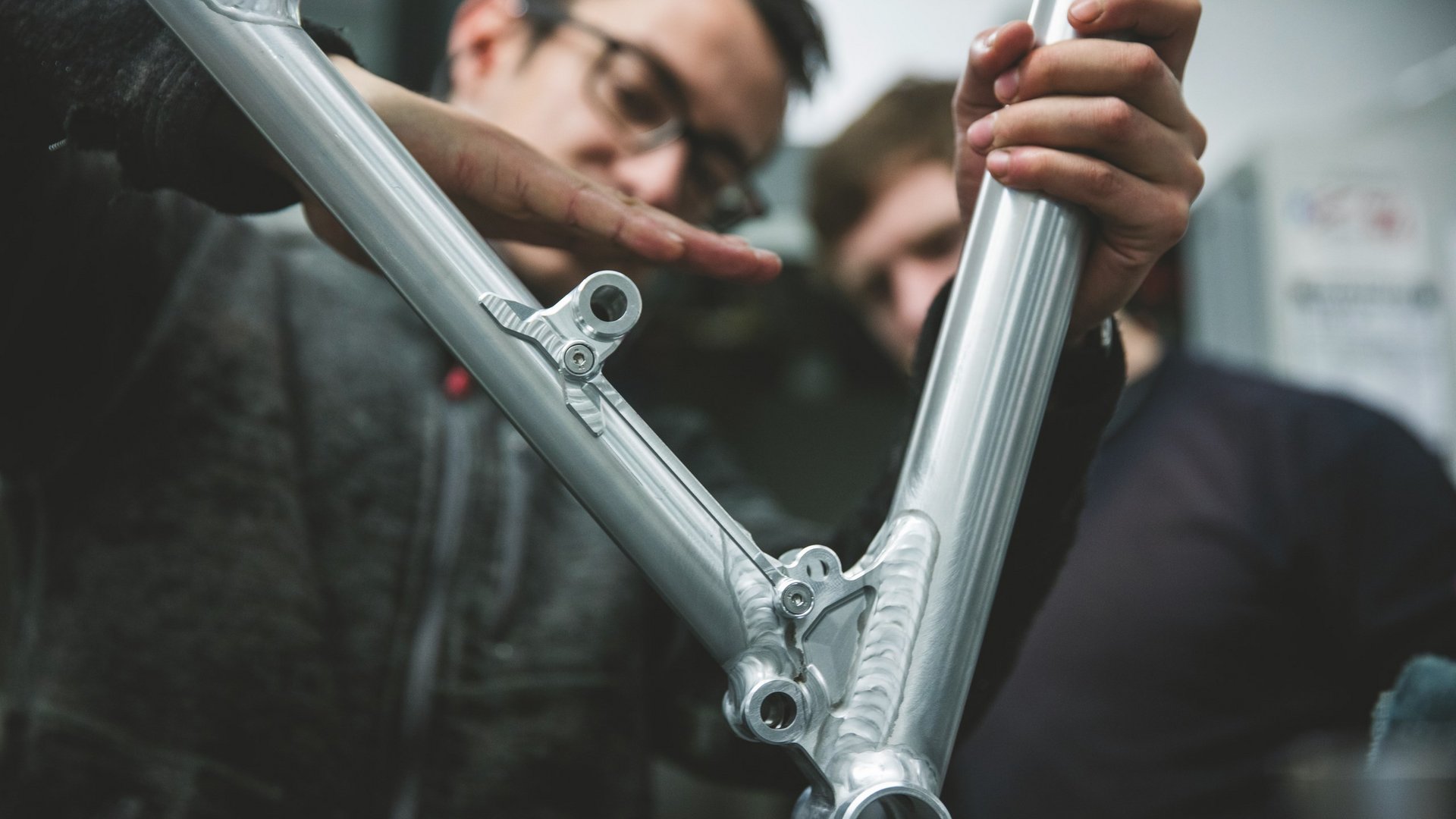 Looking for a hotel with bike rental in Bavaria? Two men inspecting a shiny aluminum bicycle frame