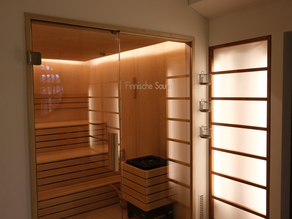 Wellnesshotel Parsberg – Romantik Hotel Hirschen Innenraum einer finnischen Sauna mit Holzbänken und Backofen