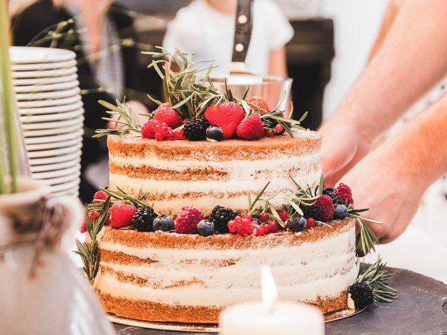 Romantik Hotel Hirschen: Bildergalerie Zweistöckiger nackter Kuchen mit Beeren und Rosmarin dekoriert