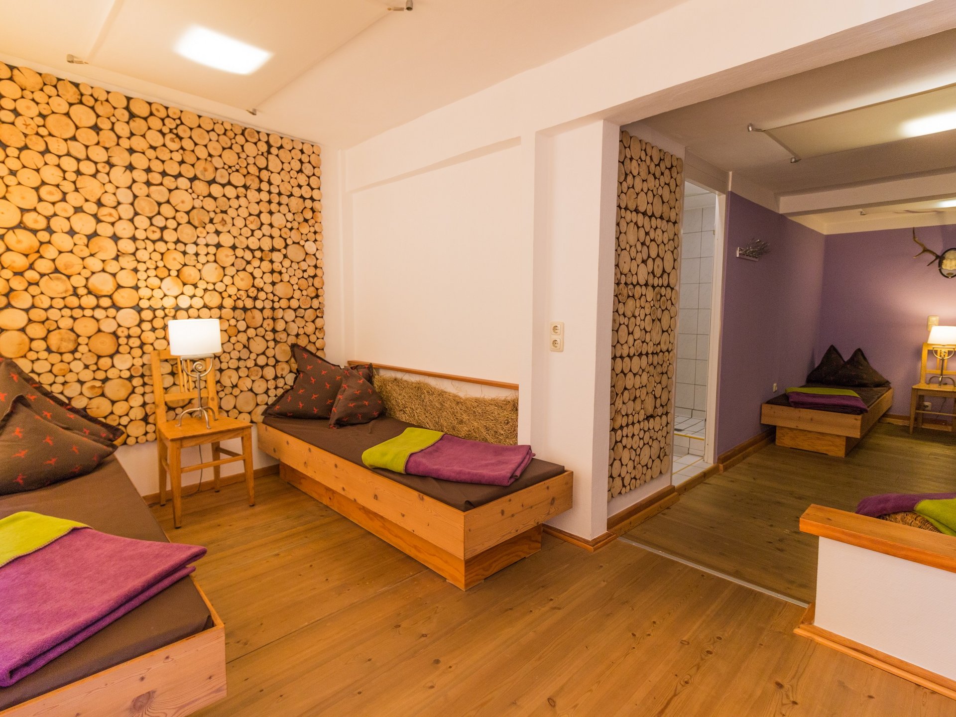 Everything you need for your stay. Cozy relaxation room with wooden furniture and log slice wall decoration
