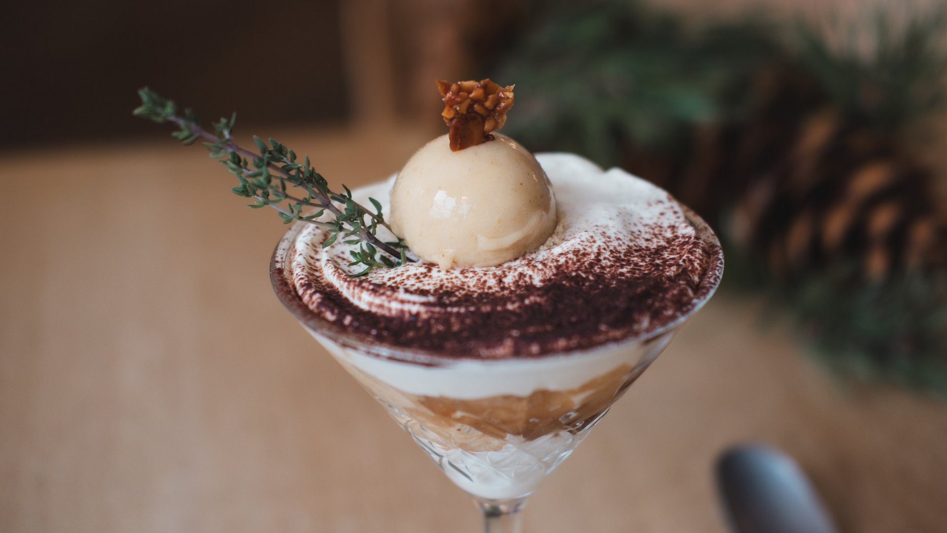 Gasthof Parsberg: Ein Gruß an den guten Geschmack Dessert im Glas mit Sahne, Kakaopulver und Eiskugel garniert mit Kräutern