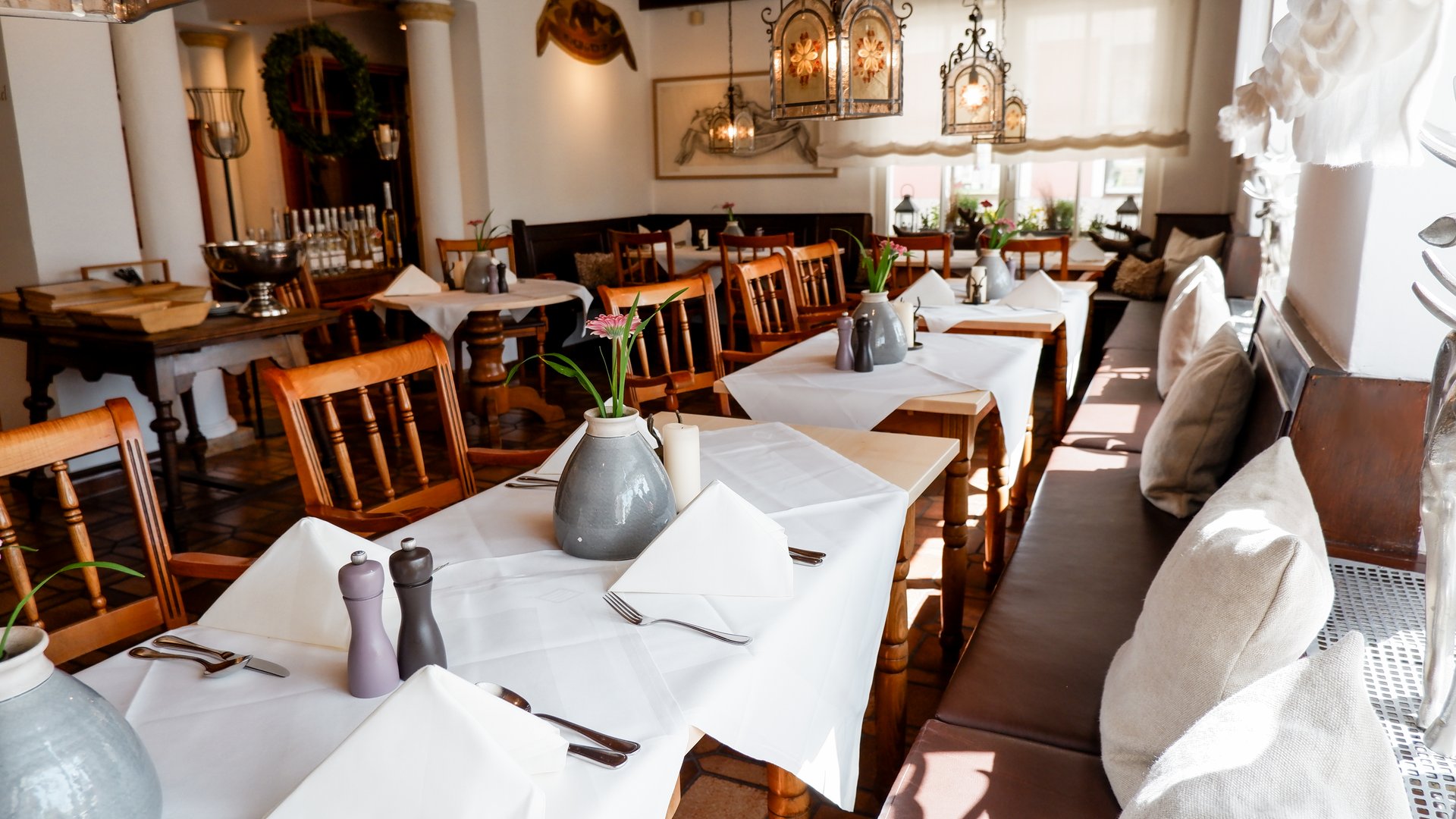 Romantik Hotel Hirschen: cuisine Cozy restaurant with white tablecloths, wooden chairs, and table decorations