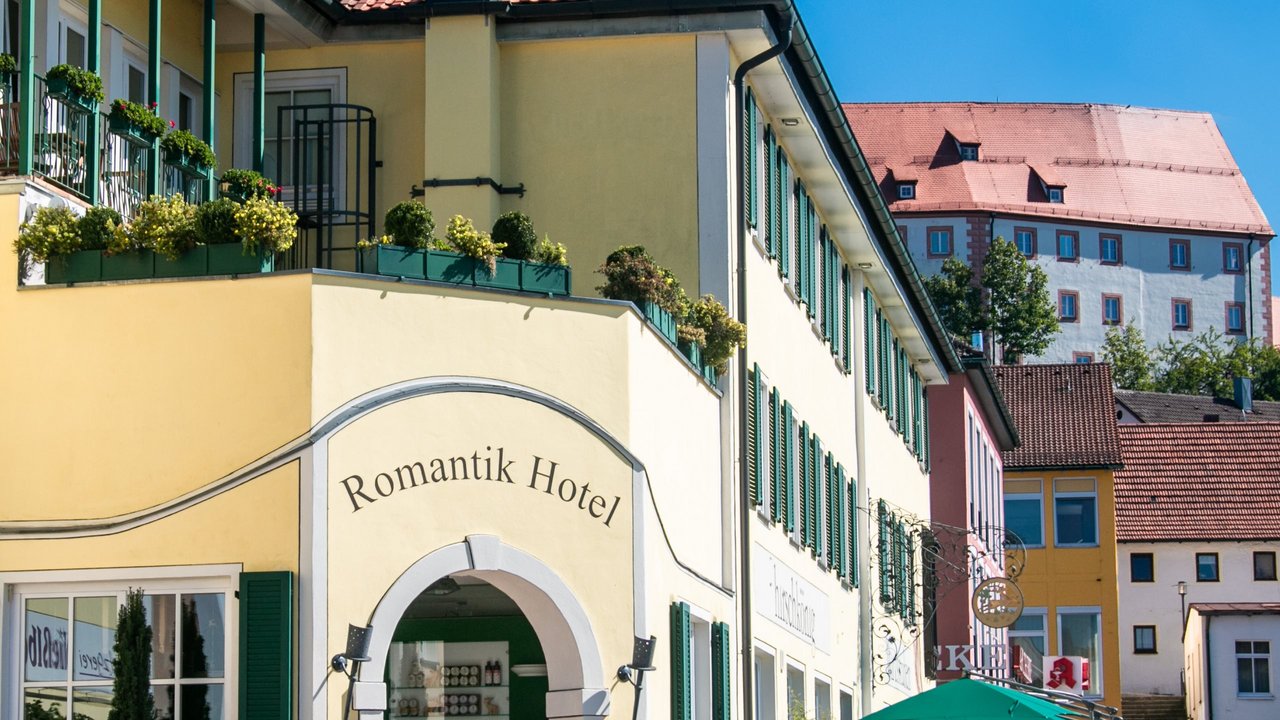 Das Romantik Hotel Hirschen in bewegtem Bild Eingang des Romantik Hotels in gelbem Gebäude unter blauem Himmel