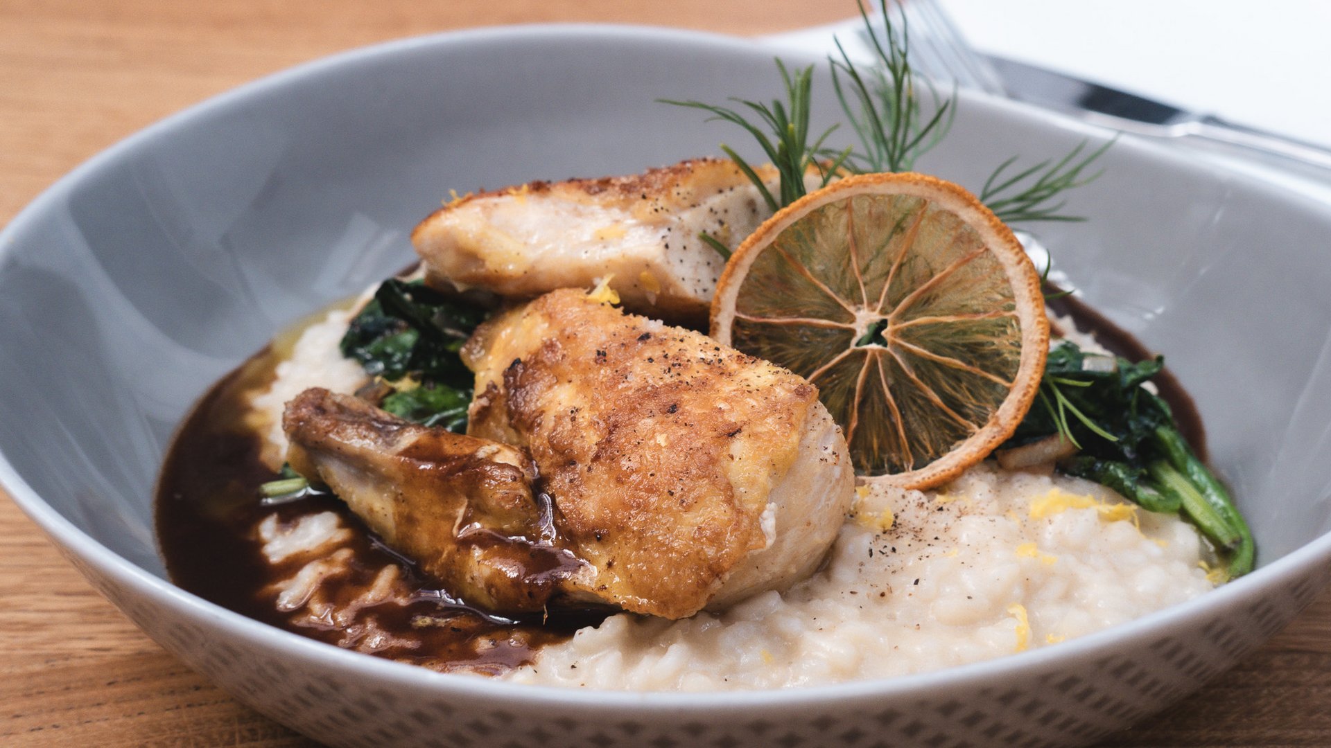 Romantik Hotel Hirschen: Kulinarik Gebratener Fisch mit Gemüse und Reis in grauer Schüssel serviert