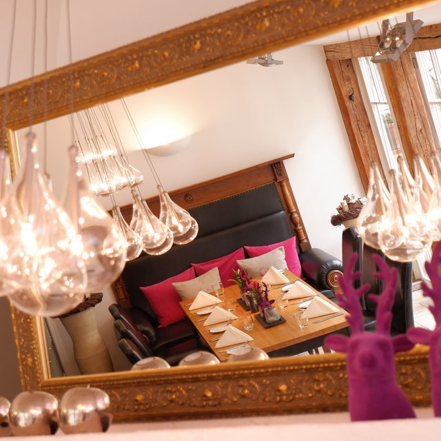 Inclusive services: Everything a stag could want. Mirror reflection of a set dining table with hanging light bulbs and pink decorations