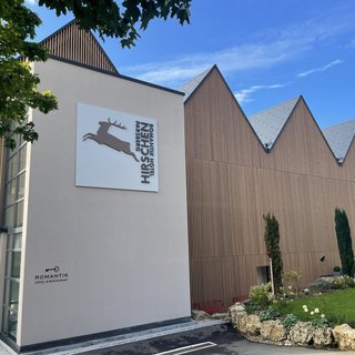 Nachhaltige Hotels in Deutschland gesucht? Außenansicht vom Romantik Hotel Hirschen mit brauner Holzfassade und grünem Garten