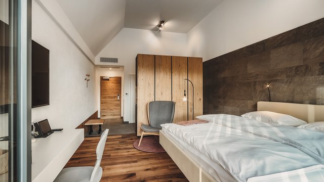 Day wellness in Upper Palatinate Modern hotel room with wooden floor, bed, wardrobe, and television