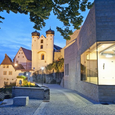 Hotels in Regensburg und Umgebung: kultur-trächtig! Historische Burganlage bei Abenddämmerung mit beleuchteten Gebäuden