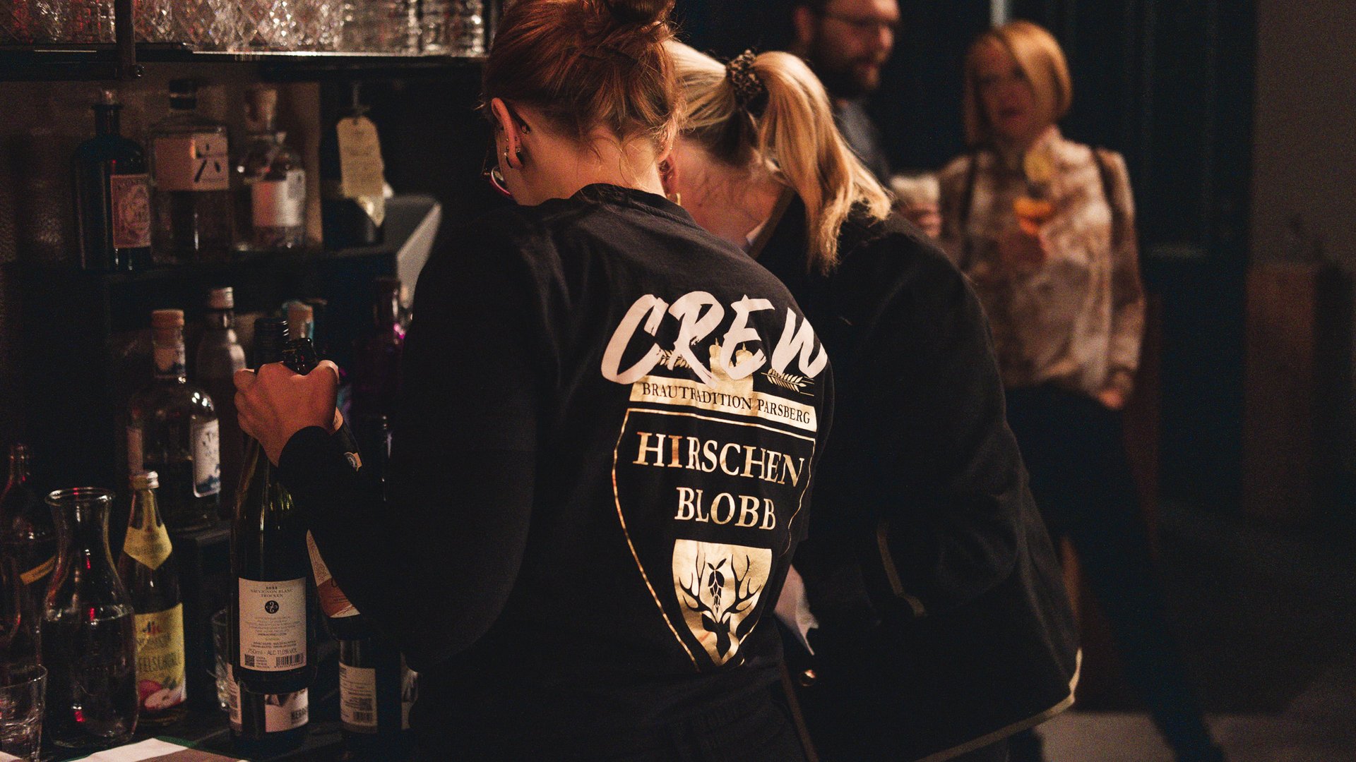 Hirschenblobb: Our bar Bar crew serving drinks with customers in the background