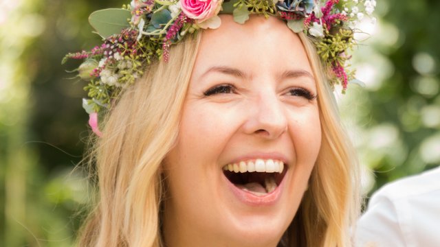 Romantik Hotel Hirschen: Blog Lachende Frau mit Blumenkopfschmuck bei sonnigem Outdoor-Event