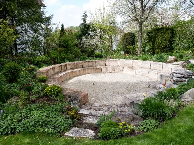 Romantik Hotel Hirschen: Bildergalerie Steinrunde Bank im Garten umgeben von Blumen und Büschen