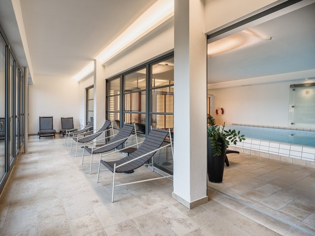 Romantik Hotel Hirschen: picture gallery Seating area with loungers next to an indoor pool in a modern interior