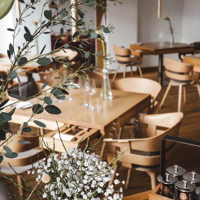 Restaurant in Parsberg: Gourmet genießen Hell eingerichtetes Restaurant mit Holzstühlen und dekorativen Pflanzen.