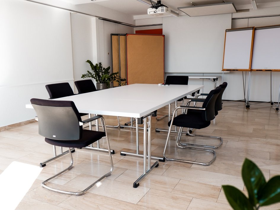 Tagungshotel Oberpfalz: Das Hotel für Deine Tagung Moderner Konferenzraum mit weißem Tisch und schwarzen Stühlen