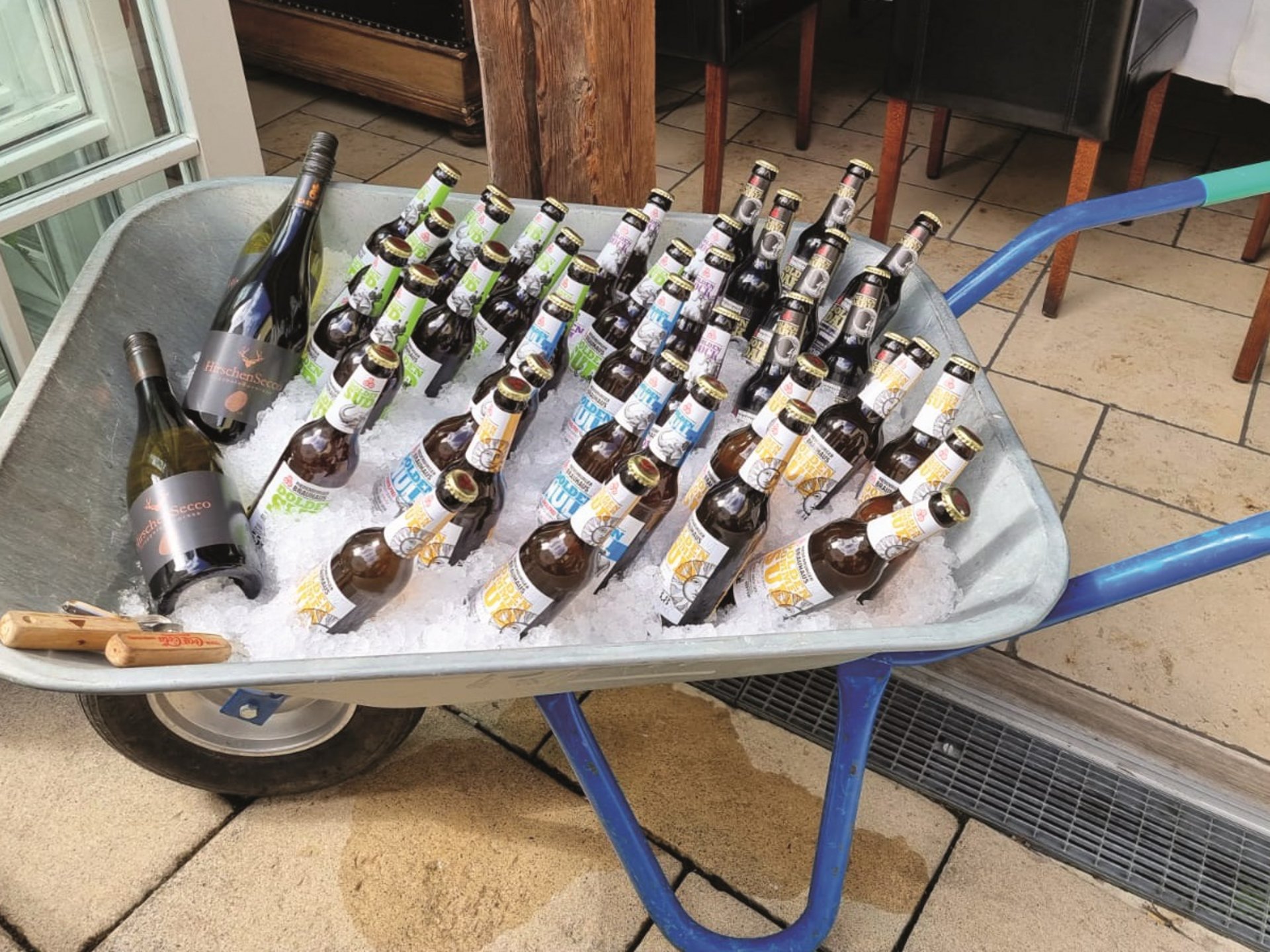 Team Building, Corporate Events & Social Programs Wheelbarrow filled with ice holding beer and wine bottles outdoors