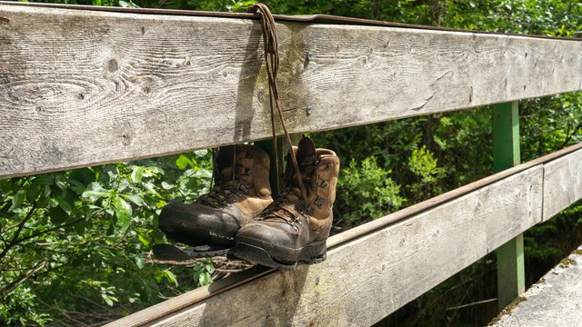 Romantik Hotel Hirschen: Blog Abgenutzte Wanderschuhe hängen an einem Holzzaun im Wald