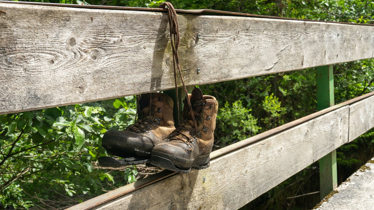 Enjoy nature along the Vilstal hiking trail Worn hiking boots hanging on a wooden fence in a forest