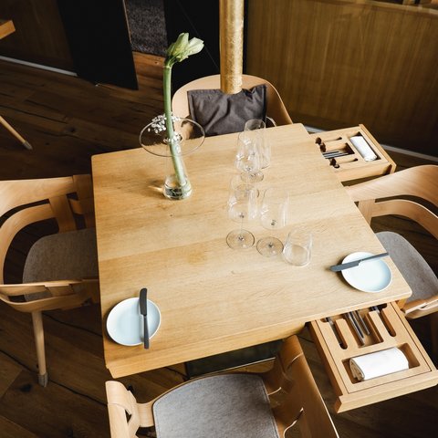 Restaurant in Parsberg: Gourmet genießen Holztisch mit vier Stühlen, Gläsern, Tellern und einer Blume in Vase
