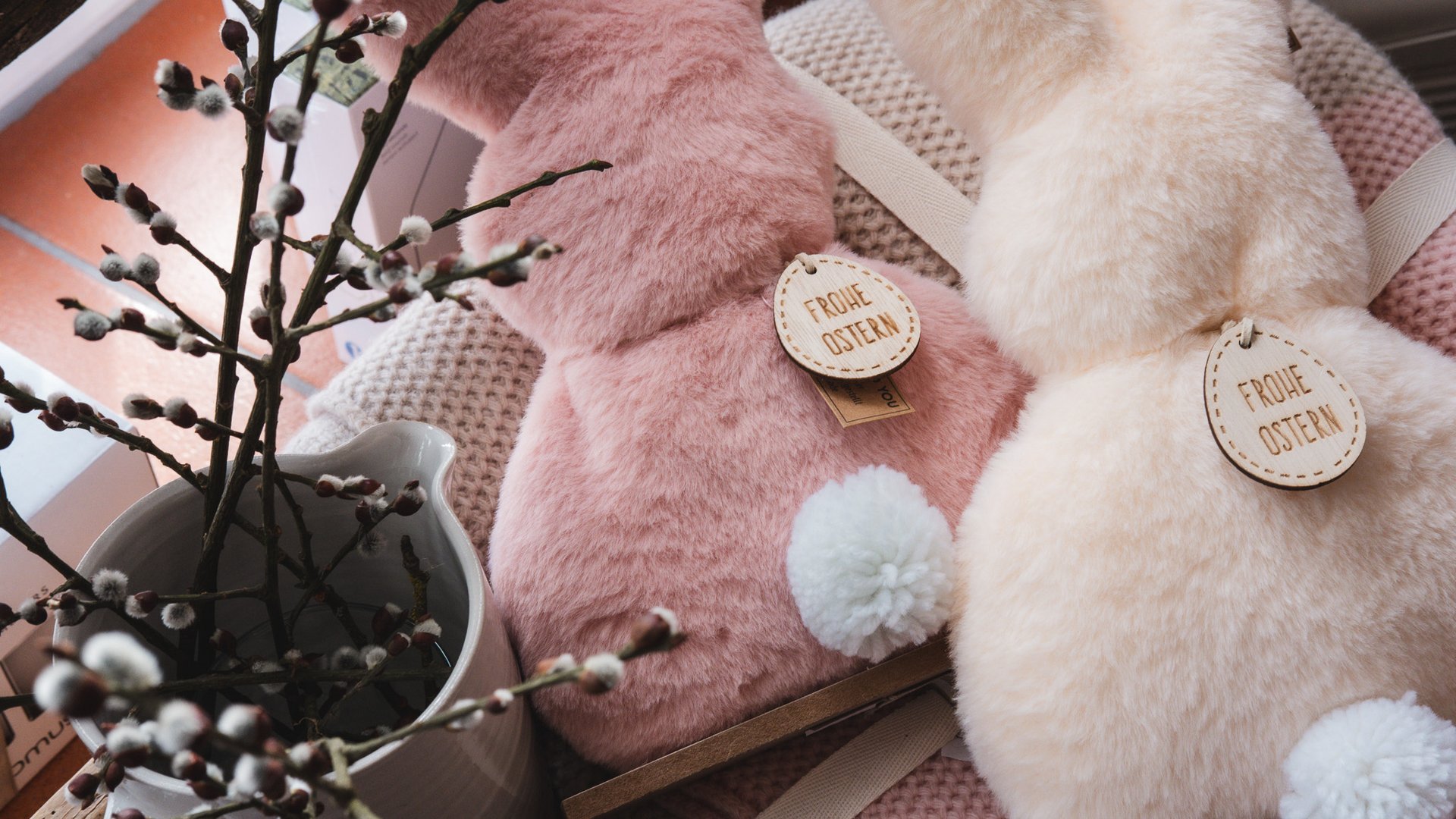 Nachhaltiges Hotel in Bayern mit Hirschenmanufaktur Zwei flauschige Osterhasen-Dekorationen mit Pompons und Weidenkätzchen
