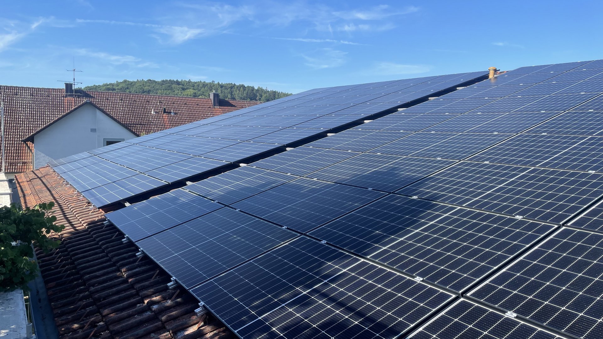 Nachhaltige Hotels in Deutschland gesucht? Solaranlagen auf einem Hausdach bei klarem Himmel