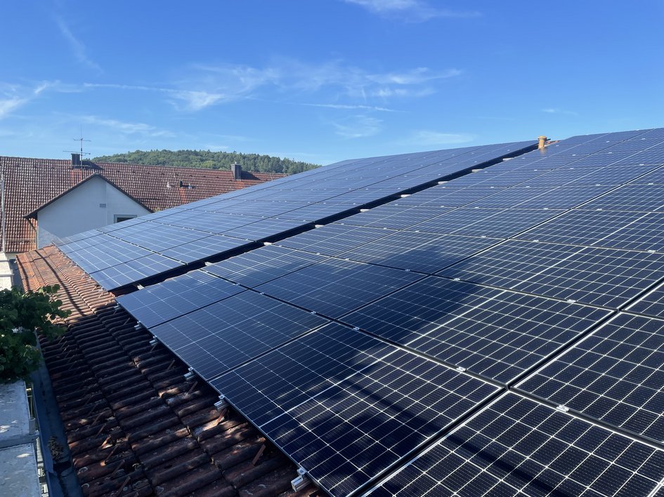 Nachhaltige Hotels in Deutschland gesucht? Solaranlagen auf einem Hausdach bei klarem Himmel