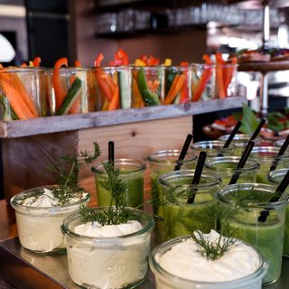 Leistungen und Preise für Tagungen und Konferenzen Verschiedene Gemüsesticks und grüne Smoothies mit Dips auf einem Buffet