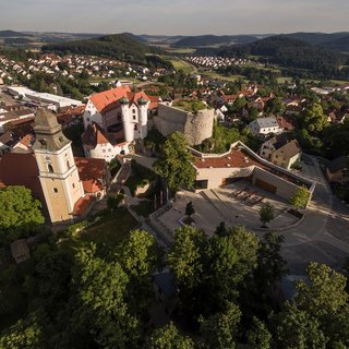 Gasthof Parsberg: Ein Gruß an den guten Geschmack Luftaufnahme von Schloss und Stadt in grüner Hügellandschaft