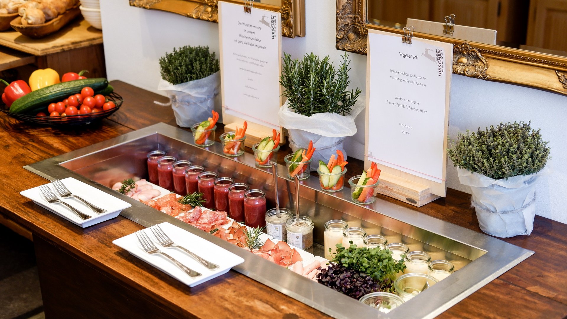 Romantik Hotel Hirschen: Frühstück Buffet mit Wurst, Aufstrichen, Gemüsesticks und Kräutern auf Holztisch