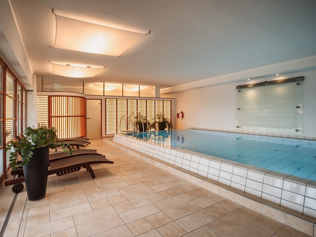 Romantik Hotel Hirschen: picture gallery Indoor swimming pool with lounge chairs and plants in bright room