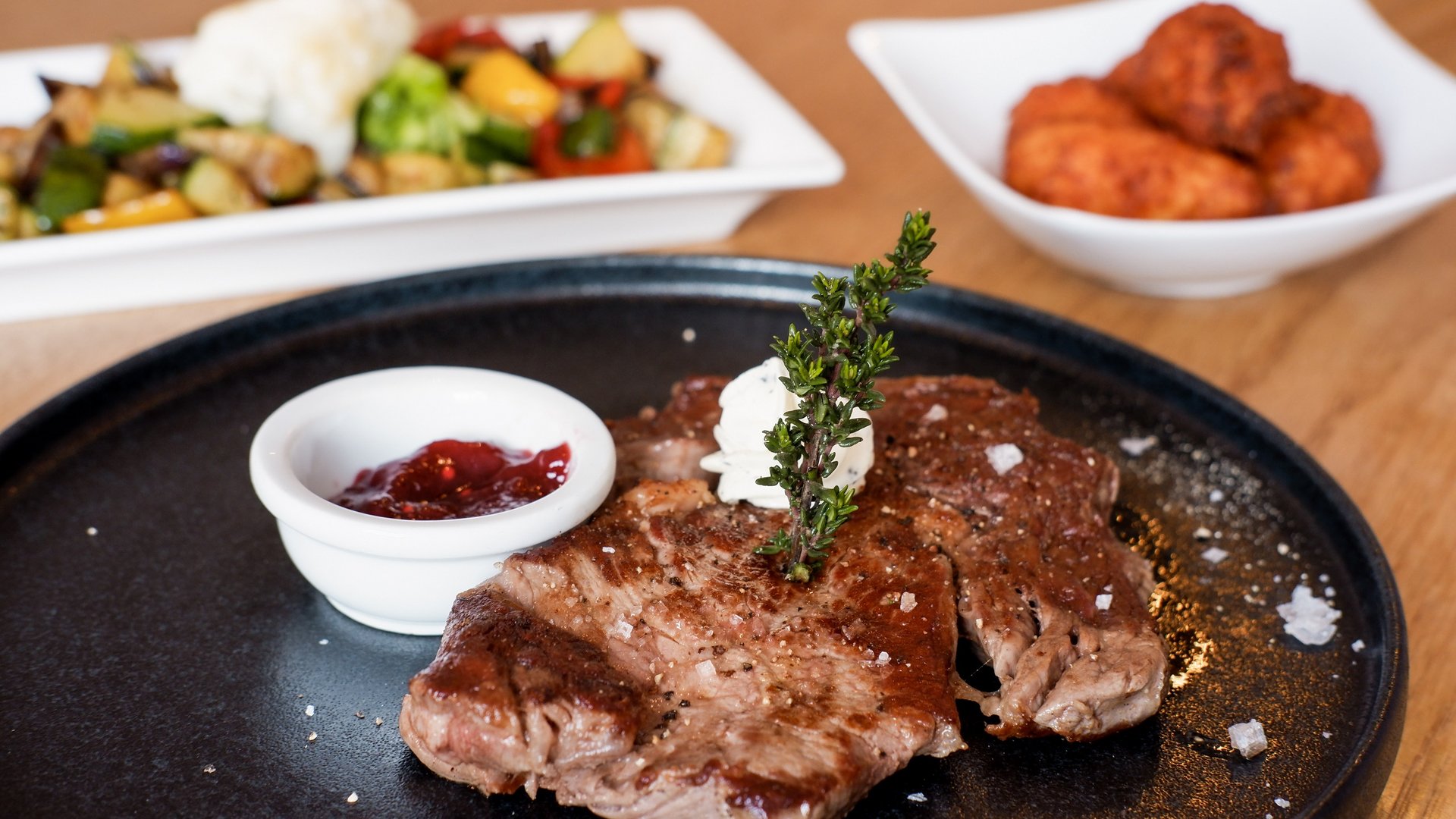 Guesthouse in Parsberg: A salute to great taste Grilled steak with herb butter, sauce, and vegetables on plates