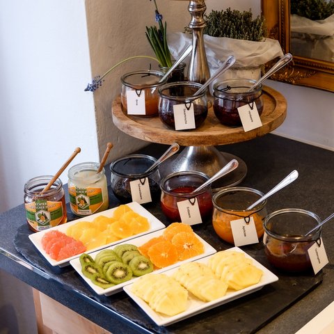 Romantik Hotel Hirschen: Frühstück Verschiedene Marmeladen, Honig und frisches Obst auf einem dreistöckigen Holzständer