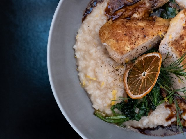 Romantik Hotel Hirschen: Bildergalerie Gebratenes Hähnchen mit Reis, grünem Gemüse und Zitronenscheibe auf Teller