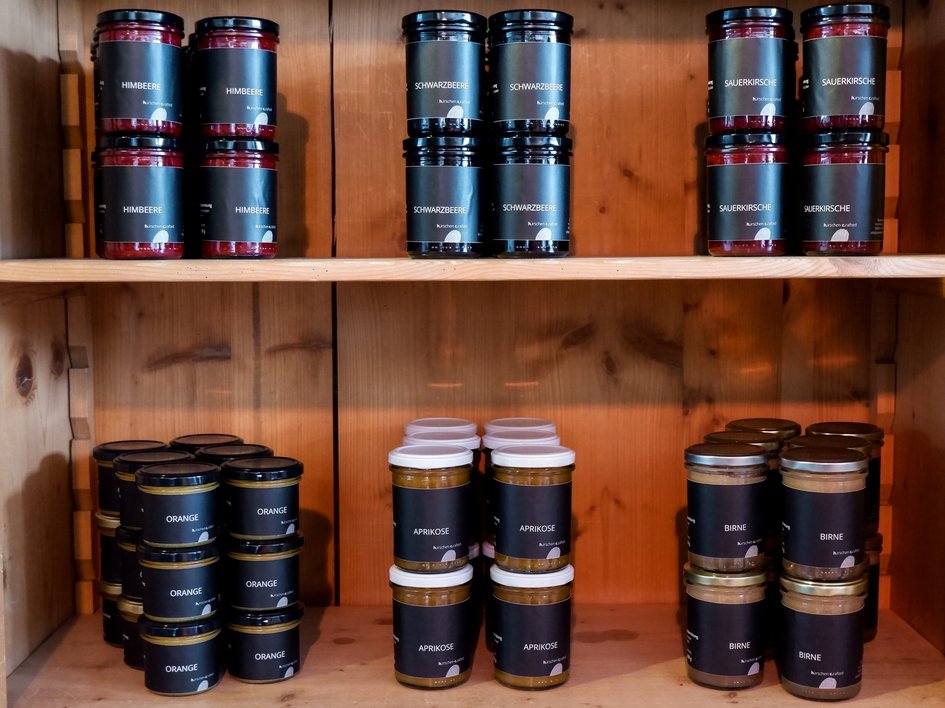 Nachhaltiges Hotel in Bayern mit Hirschenmanufaktur Verschiedene Marmeladengläser in einem Holzregal sortiert