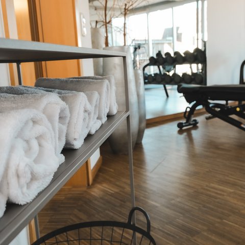 Fitnessraum Folded white towels in gym near dumbbells and workout bench